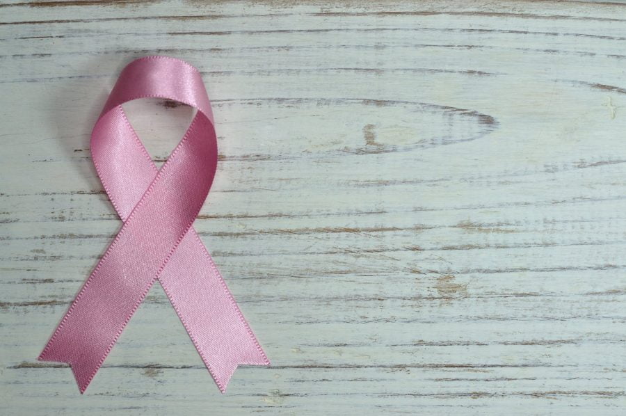 Breast cancer and sleep connection, breast cancer awareness pink ribbon on a wooden table