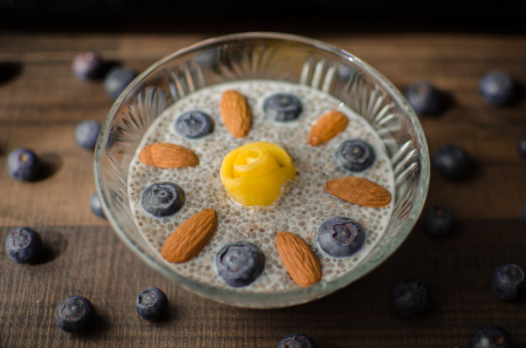 A bowl contains a harmonious arrangement of chia seeds, blueberries, and almonds.