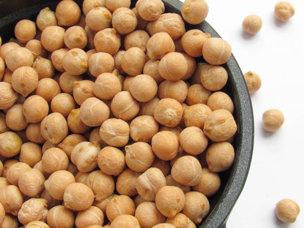 A bowl holds a generous serving of chickpeas, their pale beige color filling the container.